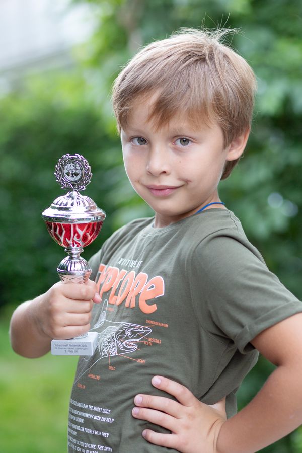 Maksim zeigt stolz seinen ersten Schachpokal